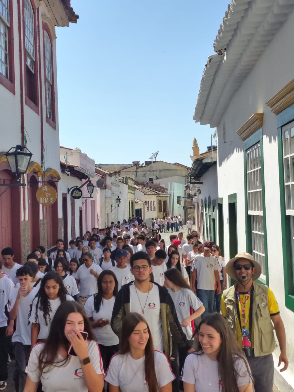 Prudêncio guiando um grupo de estudantes por uma rua de casarões coloniais